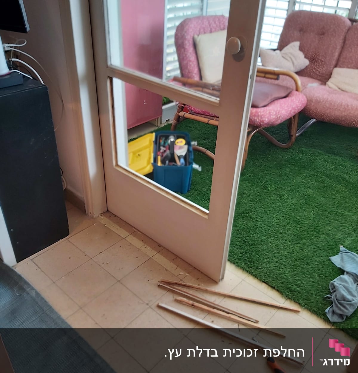 דלת עם זכוכית חסרה וכלי עבודה על הרצפה